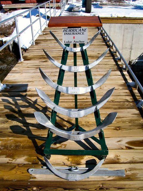 A rack of Luke storm anchors on a dock in winter, the flukes stacked one above the next in ascending sizes.