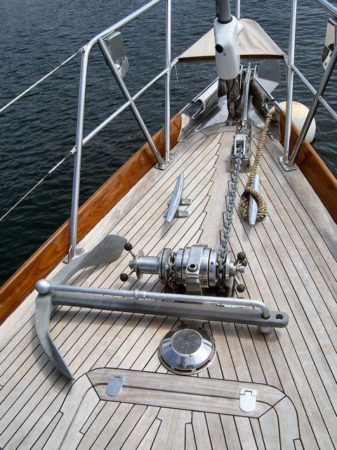 A Luke storm anchor stowed on the teak foredeck of a sailboat.