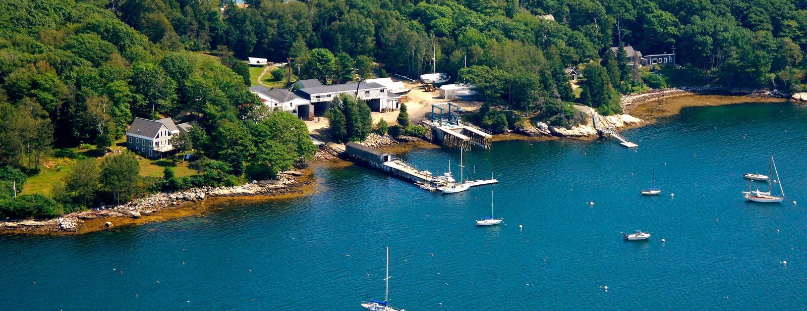 Linekin Bay from the air, with the boatyard's docks and moored boats along the East Boothbay shore.