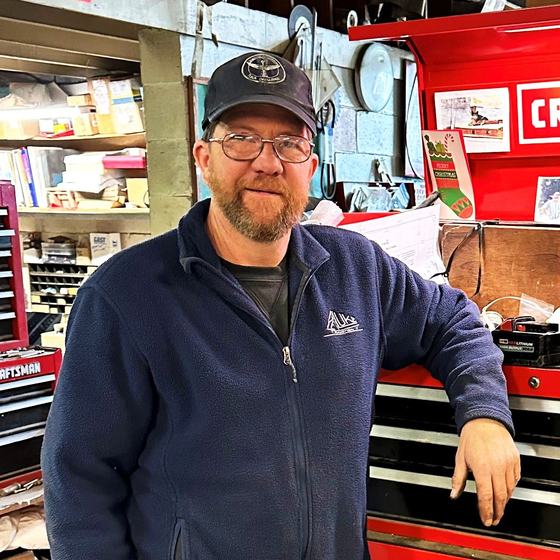 Keith Royal in the yard workshop beside a red tool chest.