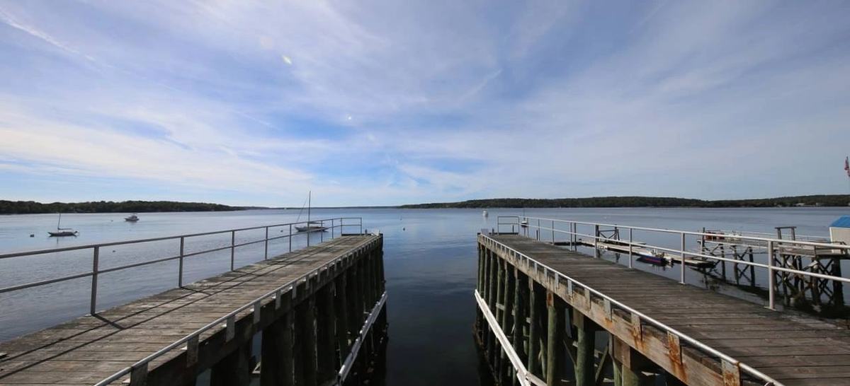 The yard's two piers running out into Linekin Bay under a high sky, with boats on moorings beyond.