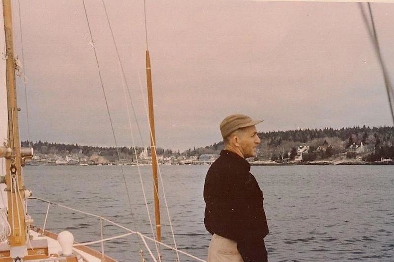 An archive photograph from the yard's own history page: a man at the rail of a boat off the Maine coast.