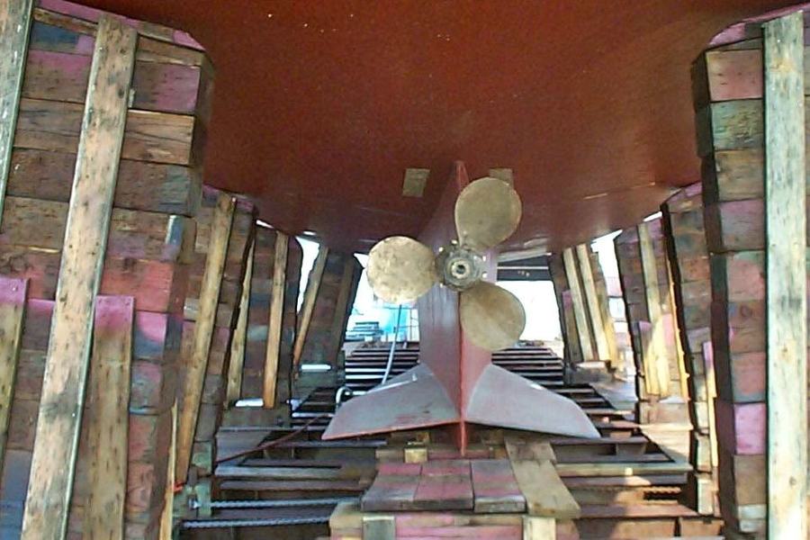 A Luke propeller fitted on the shaft of a boat blocked up in the shed.